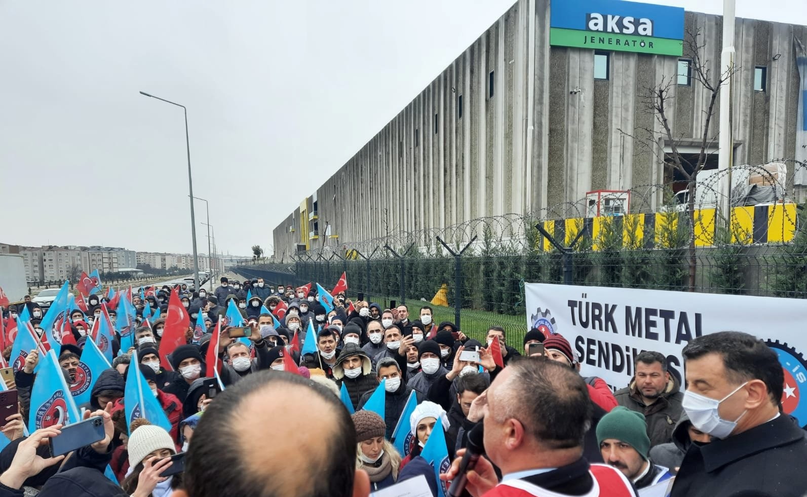 Tekirdağ Çerkezköy OSB’de bulunan Aksa Jeneratör işçileri enflasyon karşısında hızla eriyen maaşları ve kötü çalışma koşullarını düzeltmek için örgütlenme yolunu seçtiler. Türk Metal sendikasında örgütlenen işçiler belli bir çoğunluğu sağladıktan sonra fabrika, başta öncülerden 10 işçiyi, ardından da 5 ve son olarak da 6 işçiyi, yani peyderpey işten çıkarmalarla toplamda 21 işçiyi işten çıkardı. Fabrika önünde direnişe başlayan işçiler sendikalarıyla beraber yaklaşık bir aydır ekmek ve hürriyet mücadelesi v